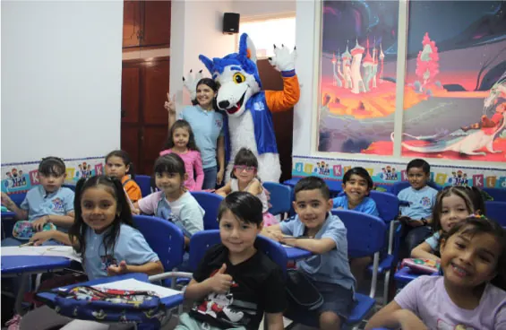 Niños de IPT Kids en su salón junto a la mascota de la academia